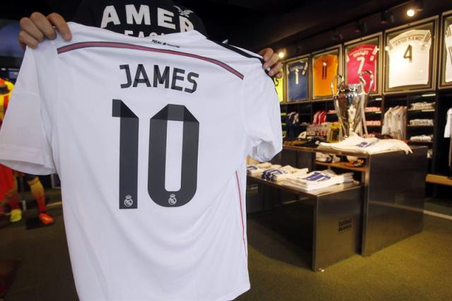 Una persona muestra una de las camiseta de James Rodríguez, que han puesto a la venta en varias tiendas deportivas, el más reciente fichaje del Real Madrid CF, considerado el tercero más caro del club y por el que han pagado 80 millones de euros. El mediocampista colombiano fue presentado el pasado martes como nuevo jugador del Real Madrid CF. EFE/Hugo Ortuño