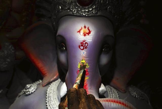 Un artista indio pinta la cabeza de elefante del dios Ganesha durante los preparativos para el tradicional Festival Ganesha. EFE