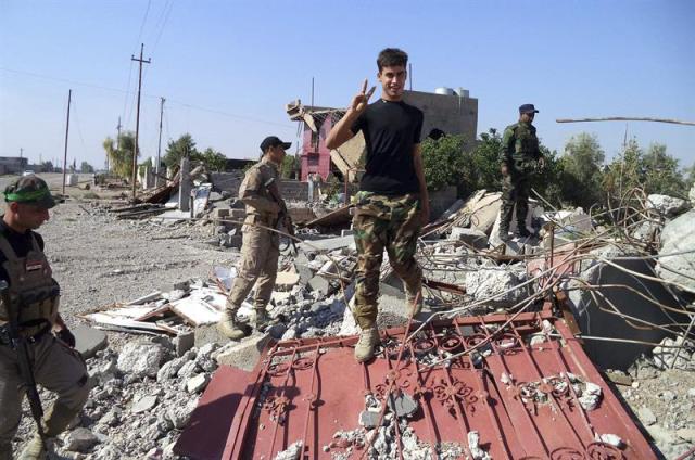 Miembros de la milicia iraquí chií Kataib Al-Jurasani, que lucha contra el Estado Islámico junto a las fuerzas de seguridaed iraquíes, inspeccionan los restos de una casa destruída durante los combates en el este de Tikrit, en el norte de Irak, hoy, martes 28 de octubre de 2014. EFE/Ali Mohammed