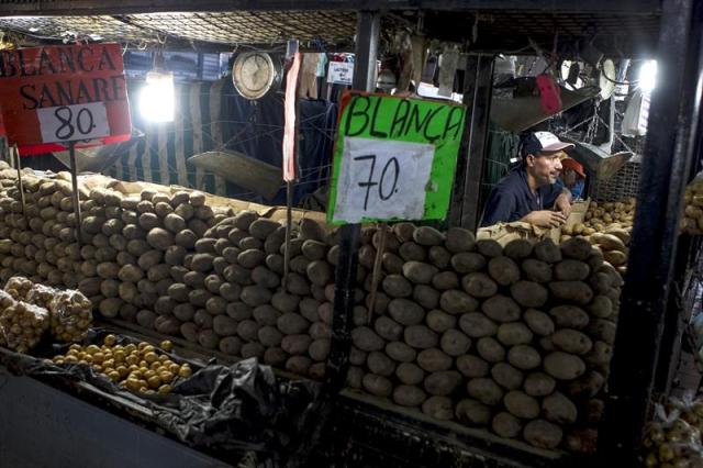 Un comerciante ofrece papa para la venta en un mercado popular hoy, miércoles 5 de noviembre de 2014, en Caracas (Venezuela). En Venezuela, una familia promedio debe peregrinar por "el menor costo posible" para completar una canasta alimentaria que, aún subvencionada, está un 17 por ciento por encima del salario mínimo y que es irreal con un mercado que ignora las regulaciones del Estado. EFE/Miguel Gutiérrez