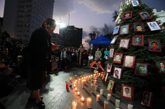 Organizaciones civiles colocan veladoras en torno a un árbol navideño en la alameda central en Ciudad de México, tapizado con las fotografías de los estudiantes desaparecidos en Guerrero. Los padres de los 43 estudiantes desaparecidos el 26 de septiembre en México dijeron hoy que el diálogo con las autoridades está suspendido, si bien tienen la intención de reanudarlo para obtener información sobre las pesquisas. EFE/Sáshenka Gutiérrez