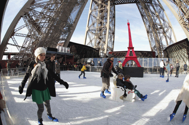 Turistas patinan en la pista de hilo de la Torre Eiffel en París, hoy 9 de diciembre de 2014. La pista de patinaje se abre al público como parte de la temporada de vacaciones de Navidad. REUTERS / Charles Platiau