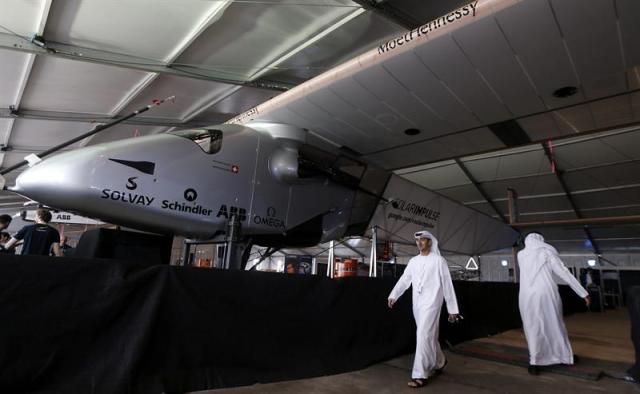 Varios visitantes pasan delante del avión solar Solar Impulse 2 durante una rueda de prensa en Abu Dabi (Emiratos Árabes Unidos) hoy, martes 20 de enero de 2015. El Solar Impulse 2 despegará de Abu Dabi a finales de febrero o principios de marzo para dar la vuelta al mundo y regresar a finales de julio o principios de agosto de 2015. EFE/Stringer