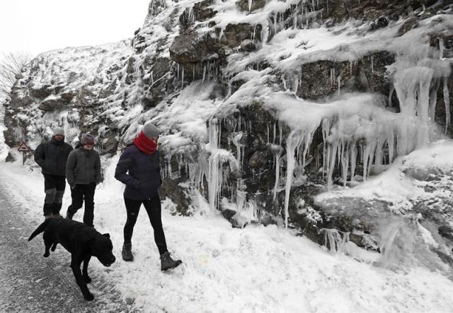 Un grupo de jóvenes, junto con su perro pasean por la N-718 en el alto de Urbasa donde las bajas temperauras de estos días han propiciado la formación de carambanos de hielo junto a la carretera. Las previsones anuncian para los próximos días descenso de tempraturas y de la cota de nieve. EFE/Jesús Diges