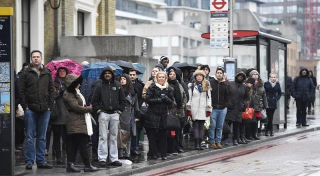 Un grupo de viajeros espera la llegada de un autobús de los servicios mínimos en la estación Victoria en Londres (Reino Unido), hoy, jueves 5 de febrero de 2015. Los conductores de autobuses del consorcio de transporte londinense (TFL) han declarado una huelga de 24 horas para protestar contra las condiciones salariales y de trabajo. EFE/Andy Rain