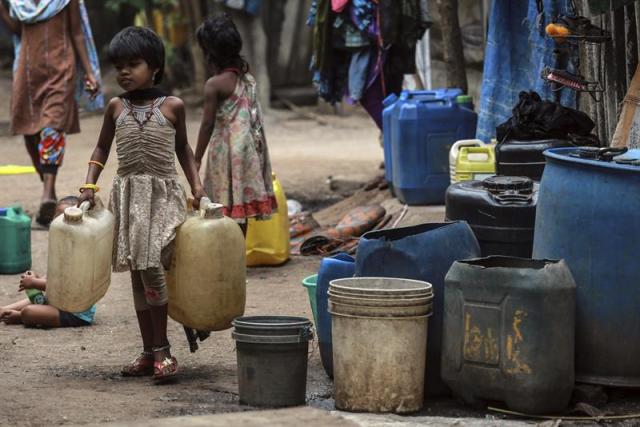 Una niña carga con dos bidones tras llenarlos de agua en una fuente pública de la localidad de Babhalichi Bhat, cerca de Bombái (India) hoy, martes 14 de abril de 2015. Más de 500 personas dependen del suministro de agua que ofrece esta fuente que solo funciona durante una hora cinco días a la semana. EFE/Divyakant Solanki