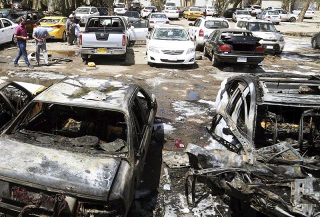 Varios iraquíes inspeccionan el lugar del atentado cerca del Hospital Al Yarmouk en Bagdad (Irak) hoy, martes 14 de abril de 2015. El coche bomba explotó en un aparcamiento frente al hospital, en el oeste de la capital, donde tres civiles fallecieron y otros diez sufrieron heridas. Al menos ocho personas murieron hoy y 24 resultaron heridas en tres atentados con explosivos perpetrados en Bagdad y sus alrededores, informó a Efe una fuente de la Policía iraquí. EFE/Ahmed Jalil