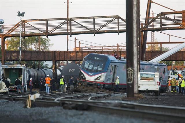 Operarios trabajan en el lugar donde un tren ha descarrilado en Filadelfia (Estados Unidos), hoy, 13 de mayo de 2015. Al menos cinco personas murieron y otras 65 resultaron heridas, seis de ellas en estado crítico, al descarrilar ayer en Filadelfia un tren de pasajeros que cubría la ruta entre Washington y Nueva York, informó el alcalde de la ciudad, Michael Nutter. El tren regional de Amtrak número 188 que hacía la ruta del noreste llevaba 238 pasajeros y 5 miembros de tripulación cuando siete de sus vagones descarrilaron en la sección de Port Richmond de Filadelfia, indicaron las autoridades. EFE/JIM LO SCALZO