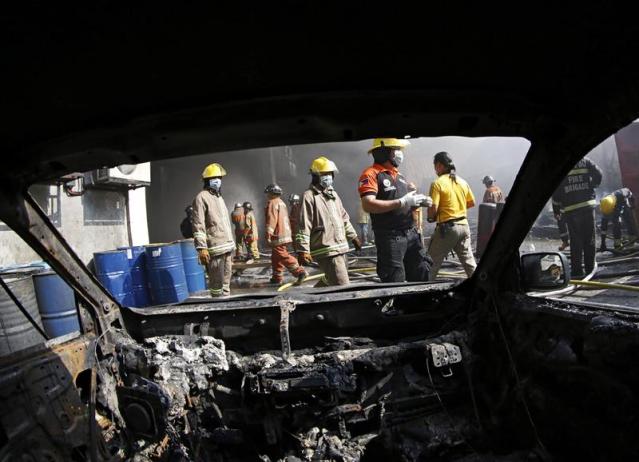 Bomberos trabajan en las labores de extinción de un incendio en un almacén en la Valenzuela, al este de Manila (Filipinas), hoy, miércoles 13 de mayo de 2015. Un total de cinco personas han muerto al quedarse atrapadas en el incendio que se originó en un almaceén de zapatillas de goma. EFE/Francis R. Malasig