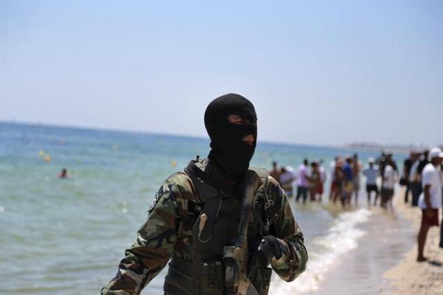 Un efectivo de la Guardia Nacional tunecina vigila la playa donde se produjo el atentado cerca del hotel Imperial Marhaba en Susa (Túnez), hoy, 29 de junio de 2015. El número de ciudadanos británicos muertos en el atentado del viernes en Túnez asciende ya a 18, aunque se teme que la cifra sea mucho mas alta, informó hoy Downing Street, residencia oficial del primer ministro, David Cameron. EFE/str