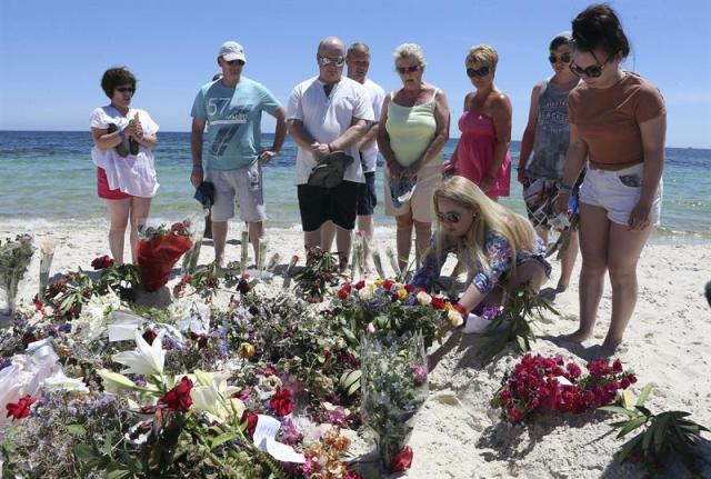 Varios turistas depositan flores en memoria de las víctimas en la playa situada frente al hotel Imperial Marhaba de Susa (Túnez) hoy, martes 30 de junio de 2015. El número de ciudadanos británicos muertos en el atentado del viernes en Túnez asciende a 21, pero se estima que hay otros nueve, informó hoy Downing Street, residencia oficial del primer ministro, David Cameron. EFE/Mohamed Messara