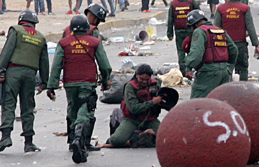 FOTOS: Una oficial de la GNB agrede en el suelo y con el casco a una mujer