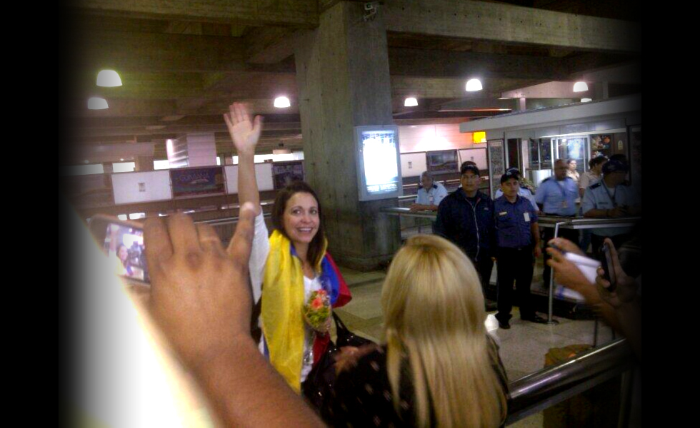 Con la bandera nacional sale María Corina Machado de Maiquetía (Fotos)