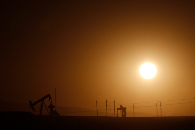 Oil derricks are seen at sunrise near Bakersfield