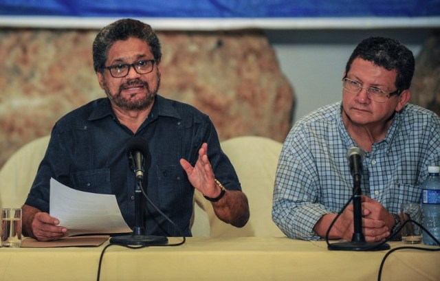 FARC commander Ivan Marquez (L) speaks during a press conference on land mine-clearing as part of the peace process between the Colombian Government and the FARC guerrillas at the Convention Palace in Havana, on July 28, 2015. The Colombian government and the Revolutionary Armed Forces of Colombia (FARC) have begun working together on clearing the country's landmines. Colombia's FARC guerrillas on Tuesday praised President Juan Manuel Santos' decision to suspend air strikes against rebel forces, but urged further steps to de-escalate the half-century-old conflict.   AFP PHOTO / YAMIL LAGE