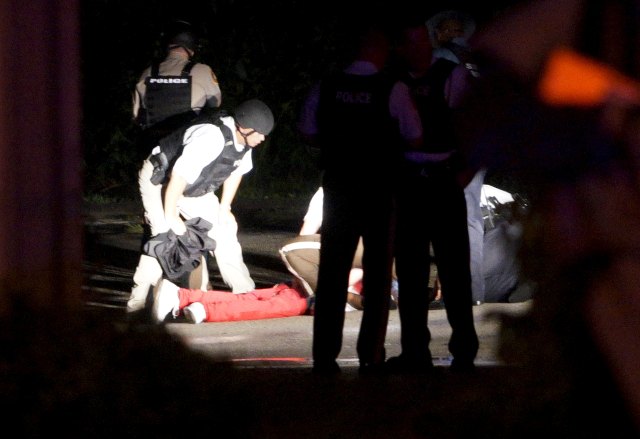 A black man lies badly wounded with blood on his shirt after a police officer involved shooting in Ferguson