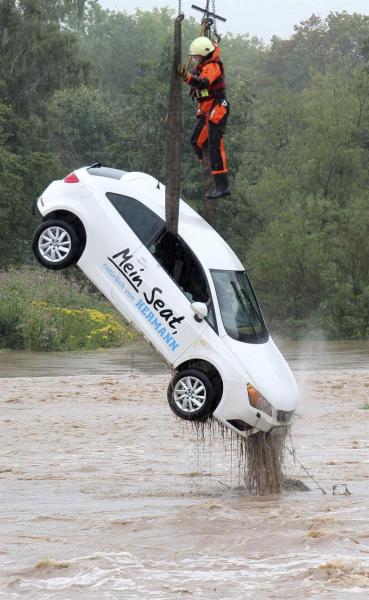 Un bombero saca del agua un coche en una zona inundada en Göttingen (Alemania) hoy, 17 de agosto de 2015. Los bomberos han trabajado toda la noche por las inundaciones causadas por las fuertes tormentas caídas en el sur del estado alemán de Baja Sajonia. EFE/Stefan Rampfel