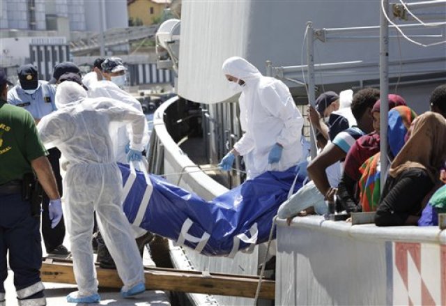 Policías forenses desembarcan el cadáver de un migrante en Reggio Calabria, Italia, el 17 de agosto del 2015. A la ciudad llegaron 49 cadáveres y más de 300 migrantes rescatados. (AP Foto/Adriana Sapone)