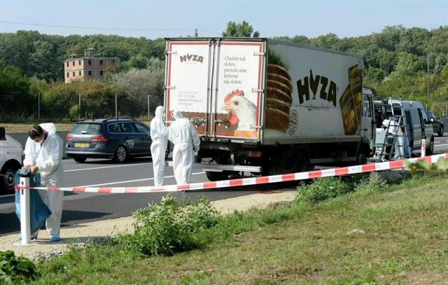 Expertos forenses realizan su trabajo en el camión frigorífico donde viajaba un grupo de inmigrantes que murieron asfixiados, en un arcén de la autopista A4, entre el lago Neusiedl y la localidad de Parndorf, en el Estado federado de Burgenland, Austria, hoy, 27 de agosto de 2015. Entre 20 y 50 refugiados, cuyas nacionalidades por el momento se desconocen, han muerto asfixiados cuando viajaban de forma ilegal por Austria en un camión. EFE/ROLAND SCHLAGER