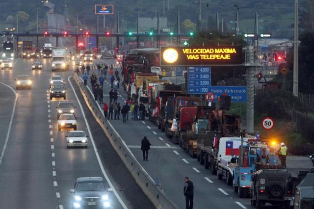 Vista de la caravana de camioneros de la Araucanía que cargan vehículos incendiados por encapuchados hoy, jueves 27 de agosto de 2015, y que fueron detenidos por Carabineros en el peaje Angostura que da acceso a Santiago (Chile). Los camioneros pretendían llegar hasta el Palacio de La Moneda donde entregarían una carta a la presidenta del país, Michelle Bachelet, para reclamar soluciones a la situación de violencia que viven en la región de la Araucanía. EFE/Elvis González