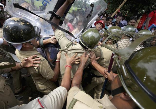 Varios miembros del Partido Comunista se enfrentan a la policía durante una manifestación en apoyo a los granjeros en Calcuta, India, hoy 27 de agosto de 2015. La ley de tierras promovida por el Gobierno ha provocado protestas y malestar en la comunidad agrícola en los últimos meses. EFE/Piyal Adhikary