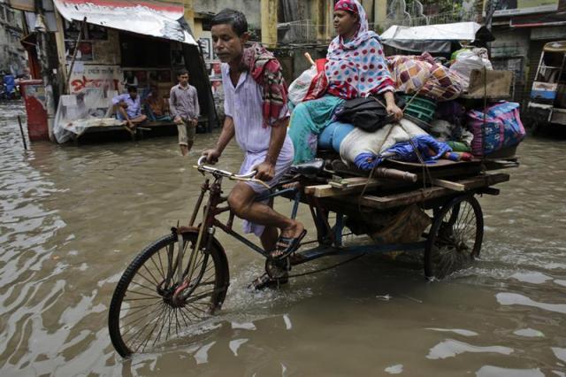 Varias personas circulan por una calle inundada de Dacca en Bangladesh hoy, 1 de septiembre de 2015. EFE/Abir Abdullah