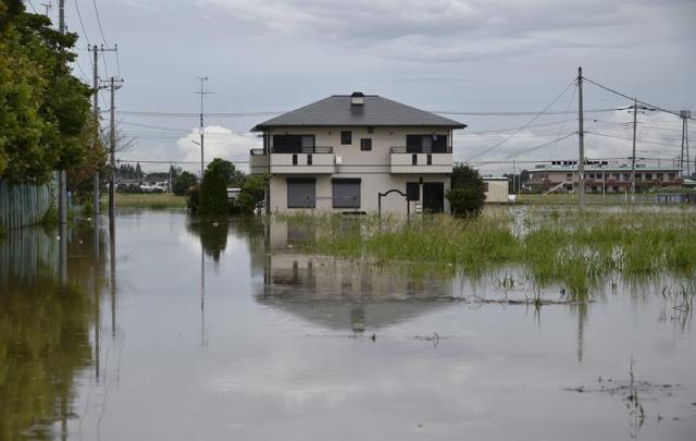 Calle inundada en Koshigaya, en el barrio de Saitama en Tokio, hoy 10 de septiembre de 2015. El tifón Etau causó hoy lluvias récord, graves inundaciones y la evacuación de casi 100.000 personas en el centro y el este de Japón, donde el fenómeno meteorológico también ha dejado al menos un desaparecido y decenas de heridos.EFE/FRANCK ROBICHON