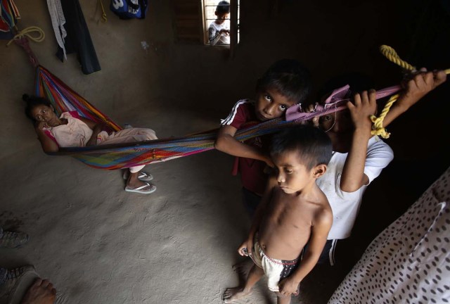 Gladis Fátima Castro descansa en su hamaca dentro de su casa con piso de tierra en Manaure, Colombia, el jueves 10 de septiembre de 2015. Hace tres días falleció su hija de 14 años y según el certificado médico la menor murió por desnutrición severa que le causó caída de pelo y úlceras en la boca que le impedían ingerir vitaminas y minerales que le habían recetado los doctores. (AP Foto/Fernando Vergara)