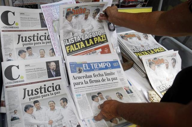 Fotografía de un puesto de periódicos hoy, jueves 24 de septiembre de 2015, en Medellín (Colombia). La prensa colombiana calificó hoy como "histórico" el convenio alcanzado ayer por el Gobierno y las FARC para firmar un acuerdo de paz antes del 23 de marzo de 2016 y sitúan en sus portadas la foto del saludo entre el presidente Juan Manuel Santos y el líder guerrillero, Rodrigo Londoño, alias "Timochenko". EFE/Luis Eduardo Noriega