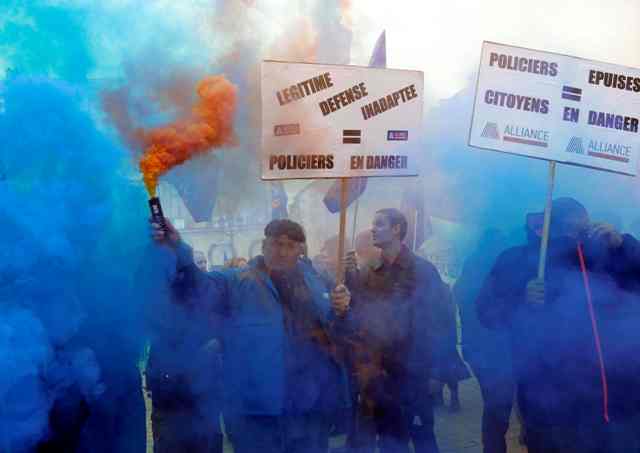 La policía francesa están detrás de las banderas sindicales que protestan cerca del Ministerio de Justicia en París, Francia, 14 de octubre de 2015. Miles de policías protestaron en las afueras del Ministerio de Justicia de Francia por primera vez en décadas el miércoles para denunciar la falta de recursos y lo que dicen es insuficiente apoyo del poder judicial en su trabajo diario cumplimiento de la ley. El lema lee "inadecuada autodefensa = policial en peligro". REUTERS / Jacky Naegelen