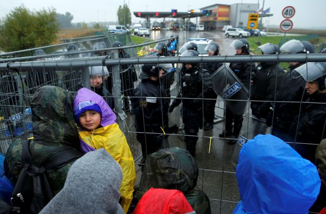 Un niño observa mientras los migrantes esperan para cruzar la frontera con Eslovenia en Trnovec, Croacia 19 de octubre de 2015. Los Balcanes enfrentó una acumulación creciente de migrantes el lunes, miles se acumulan en, bordes fríos y húmedos tras el cierre de la frontera sur de Hungría les desviaron a Eslovenia. Reuters