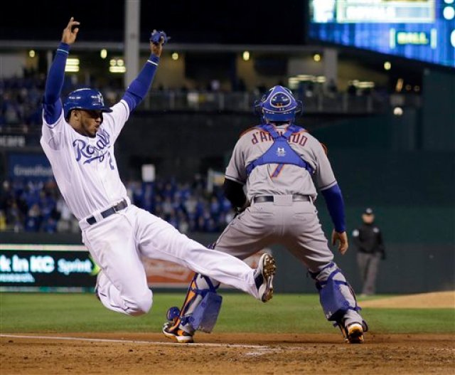 Alcides Escobar de los Reales de Kansas City se desliza en el plato al anotar una carrera en el quinto inning del segundo juego de la Serie Mundial contra los Mets de Nueva York el miércoles 28 de octubre de 2015. (AP Foto/Matt Slocum)