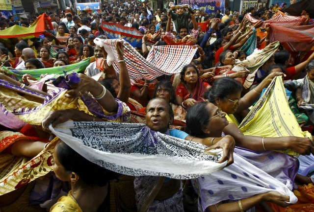 Devotos hindúes sostienen bufandas para recibir el arroz como ofrendas siendo distribuidos por la autoridad del templo con motivo del festival Annakut en Kolkata, India, 12 de noviembre de 2015. Annakut se celebra el primer día de la luna llena en el mes de Kartik, donde 56 tipos de alimentos son preparados y entregados a los adoradores. REUTERS / Rupak De Chowdhuri