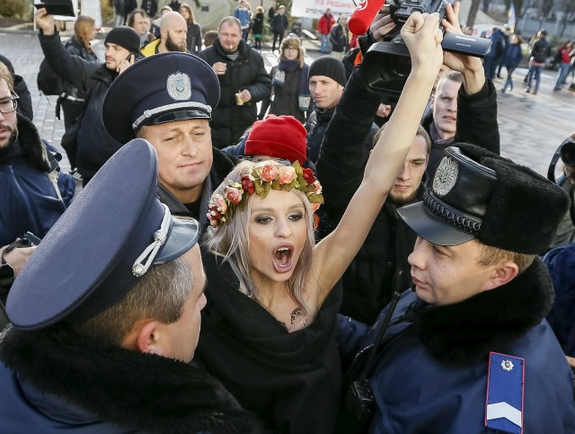 Policía ucraniana detienen a un activista del grupo de derechos de la mujer Femen como ella protesta contra la homofobia fuera del edificio del parlamento en Kiev, Ucrania, 12 de noviembre de 2015. Femen y los derechos de los homosexuales activistas están presionando al Parlamento a adoptar proyectos de ley, entre ellos uno que prohibiría la discriminación en el lugar de trabajo basado en la sexualidad, que se incluye en un paquete de leyes para liberalizar el régimen de visados de Ucrania con la UE. REUTERS / Gleb Garanich