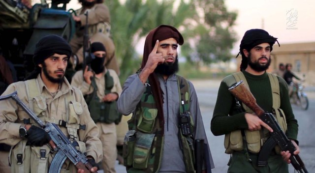 A man (C) identified in the subtitiles as Al Karar the Iraqi, an Islamic State fighter, gestures as he speaks at an undisclosed location in this image taken from undated video footage released by Islamic State. Islamic State warned in the new video on November 16, 2015 that countries taking part in air strikes against Syria would suffer the same fate as France, and threatened to attack in Washington. The video, which appeared on a site used by Islamic State to post its messages, begins with news footage of the aftermath of Friday's Paris shootings in which at least 129 people were killed. REUTERS/Social Media Website via Reuters TVATTENTION EDITORS - THIS PICTURE WAS PROVIDED BY A THIRD PARTY. REUTERS IS UNABLE TO INDEPENDENTLY VERIFY THE AUTHENTICITY, CONTENT, LOCATION OR DATE OF THIS IMAGE. THIS PICTURE IS DISTRIBUTED EXACTLY AS RECEIVED BY REUTERS, AS A SERVICE TO CLIENTS. FOR EDITORIAL USE ONLY. NOT FOR SALE FOR MARKETING OR ADVERTISING CAMPAIGNS. NO RESALES. NO ARCHIVE.