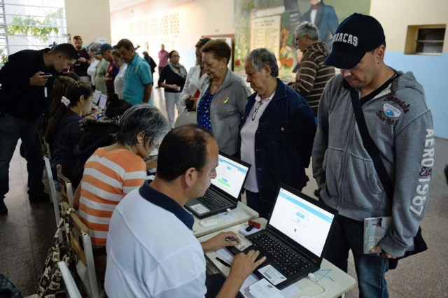 People wait to cast their vote in a polling station in Caracas, on December 6, 2015 during the Venezuela's legislative elections. For the first time in 16 years of "Bolivarian revolution" under late president Hugo Chavez and his successor Nicolas Maduro, polls show their rivals could now win a majority in the National Assembly.  AFP PHOTO/ FEDERICO PARRA / AFP / FEDERICO PARRA