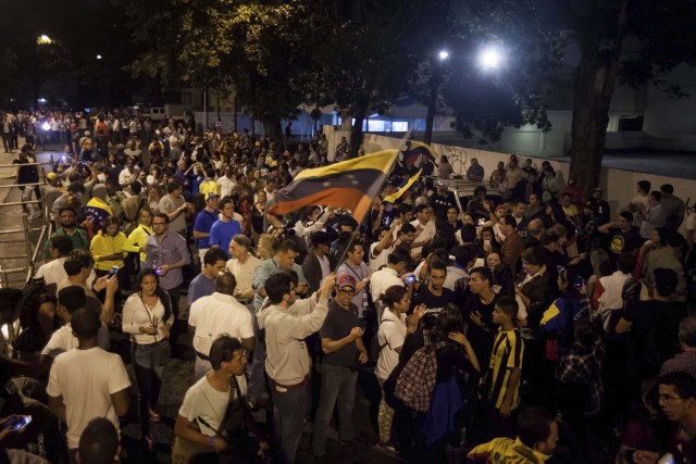 GRA009. CARACAS (VENEZUELA), 07/12/2015.- Un grupo de personas celebra la victoria obtenida por la coalición opositora Mesa de Unidad Democrática (MUD) hoy, lunes 7 de diciembre de 2015, en la ciudad de Caracas (Venezuela). La presidenta del Consejo Nacional Electoral (CNE) de Venezuela, Tibisay Lucena, anunció hoy que la alianza opositora MUD ganó las elecciones legislativas con un total de 99 diputados frente a 46 del chavismo. EFE/Miguel Gutiérrez