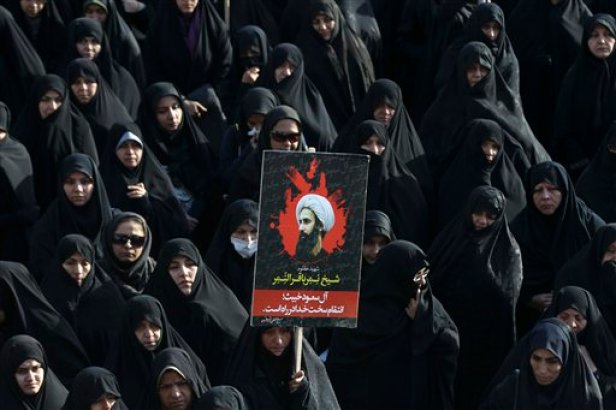 Una mujer iraní en Teherán alza un retrato del jeque Nimr al-Nimr, clérigo chiíta ejecutado en Arabia Saudí.El jueves 7 de enero de 2016 Teherán denunció un ataque aéreo saudí a su embajada en Yemen. (AP Foto/Vahid Salemi, File)