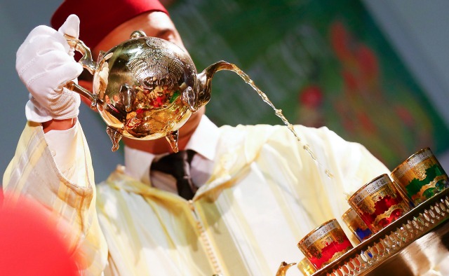 Un hombre en traje tradicional marroquí posa con té para los medios de comunicación durante los preparativos de la Semana Verde de comida internacional, la agricultura y la horticultura feria de Berlín, Alemania, 13 de enero de 2016. Marruecos es el país socio de la feria de este año. REUTERS / Hannibal Hanschke