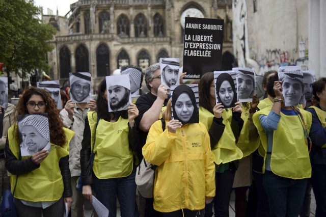 Las personas tienen fotos de Samar Badawi (C) y su hermano encarcelados Arabia blogger Raif Badawi (R), ya que demuestran en apoyo de Raif Badawi, que fue condenado a 1.000 latigazos por "insultar al Islam, el 7 de mayo, 2015, en París. El caso de Badawi, de 31 años, ha provocado la indignación y la crítica en todo el mundo de las Naciones Unidas, Estados Unidos, la Unión Europea, Canadá y otros. Badawi cofundó con Suad al-Shammari el grupo de discusión de Internet Red Liberal Arabia. fue detenido en junio de 2012 en virtud de disposiciones de cibercrimen, y un juez ordenó la página web cerró después de que criticó a la policía religiosa notorios de Arabia Saudita. Badawi fue condenado inicialmente a siete años de cárcel y 600 latigazos por insultar al Islam y la creación de la red liberal. AFP PHOTO / STEPHANE dE SAKUTIN