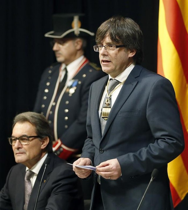 El nuevo presidente catalán, el independentista Carles Puigdemont, junto al expresidente Artur Mas (i), durante su discurso en el acto de toma de posesión que se ha celebrado hoy en el Palau de la Generalitat. EFE