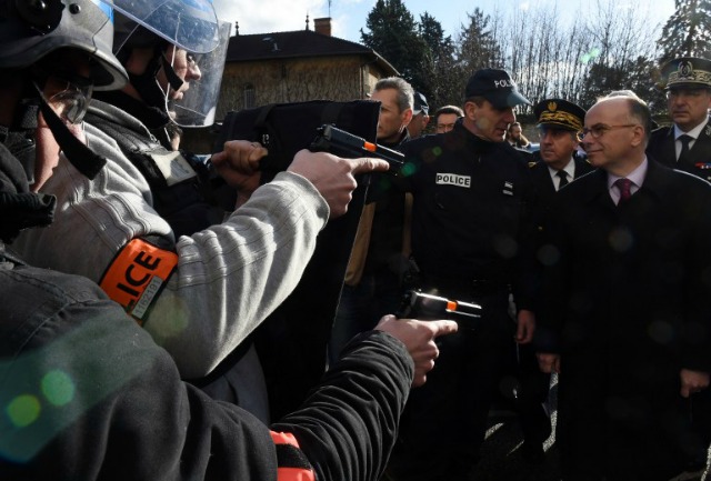 Ministro del Interior francés, Bernard Cazeneuve (R) habla con miembros del BAC (Brigada Anti-criminalité brigada -anti-crimen) durante su visita en la escuela nacional de Saint-Cyr de la policía para entregar los deseos de su Año Nuevo a la policía nacional francesa en enero 15, 2016 en Saint-Cyr-au-Mont-d'Or.