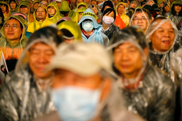 Las personas que usan capas de lluvia de plástico asisten a un Partido Democrático Progresista (DPP) campaña de rally por presidente y candidato a la presidencia, Tsai Ing-wen, un día antes de la elección en Taipei, Taiwán 15 de enero de 2016. REUTERS / Damir Sagolj