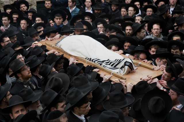 Judios ultra-ortodoxos llevan el cuerpo del rabino Refoel Shmulevitz, de 79 años, envuelta en un manto de oración, durante su funeral fuera de la escuela religiosa Mir Yeshiva en el barrio de Beit Israel de Jerusalén el 19 de enero de 2016. El rabino Refoel Shmulevitz era el jefe de la Mir Yeshiva, uno de los Yeshiva más grande de Israel con más de 7.500 estudiantes procedentes de todo el mundo.