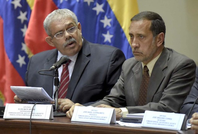 Opposition deputies Jose Guerra (R) and Elias Mata (L) talk during a session  of the National Assembly in Caracas January 21, 2016.The Venezuelan government canceled at the last minute an appearance before the Parliament to explain the situation of the economy and an emergency decree because the session would be public, legislative sources reported.  AFP PHOTO/JUAN BARRETO / AFP / JUAN BARRETO