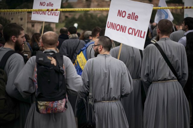 Frailes con pancartas que dicen: "No a las uniones civiles" se reúne en Roma el sábado 20 de 2016. Miles de personas que se oponen a los derechos de los homosexuales se reunieron afuera del Circus Maximus de Roma para protestar contra una ley que permitiría uniones similares al matrimonio entre parejas del mismo sexo y les otorgaría reconocimiento legal como familias. 