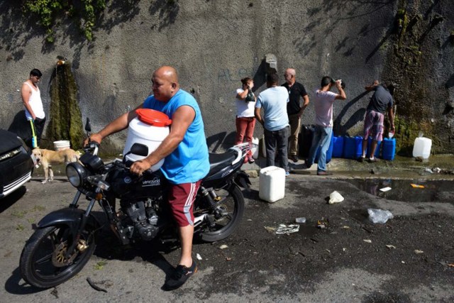 People line up to fill jerry cans with water from the Wuaraira Repano mountain in Caracas on January 21, 2016. Venezuela suffers a severe water shortage, which the government attributes to the delay in the arrival of the rainy season for the third consecutive year due to El Nino weather phenomenon. AFP PHOTO/FEDERICO PARRA / AFP / FEDERICO PARRA