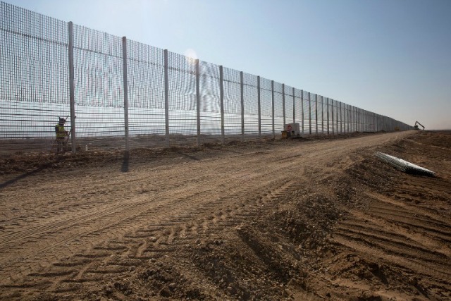 Trabajadores israelíes erigen un nuevo muro en la frontera de Israel con Jordania en el valle de Araba, a unos 30 Kilómetros al norte a la sur ciudad turística israelí de Eilat, el 1 de febrero, el 2016.