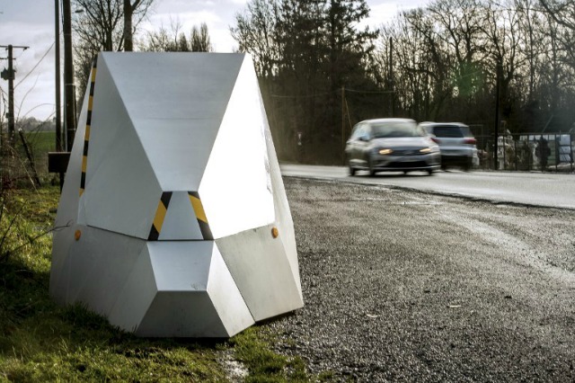 Los automóviles circulan más allá de una cámara de velocidad en la D939 en Aubigny-en-Artois el 10 de febrero de 2016, en la primera zona en Francia para ser equipado con "señales" que atraen. Once carteles que decían "Por su seguridad, el uso frecuente de las cámaras de velocidad" se instalarán en una parte de la calle lateral en el departamento de Pas-de-Calais, pero una cámara de velocidad se oculta detrás de una sola de las señales, que se ser movido regularmente.