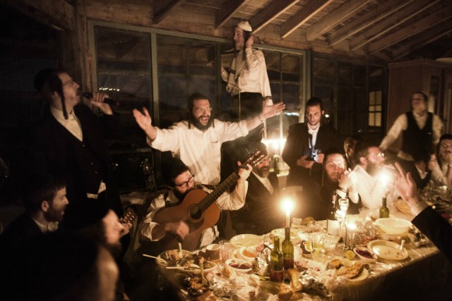 Judios ultraortodoxos comparten una cena luz de las velas para celebrar el ritual judío de "Sheva Berajot" (las siete bendiciones), también conocidas como las bendiciones de la boda, el 17 de febrero de 2016 Kadita un pueblo de la comunidad no reconocida en el norte de Israel. El ritual de celebrar durante un período de siete días después de que una pareja se casa MENAHEM KAHANA / AFP